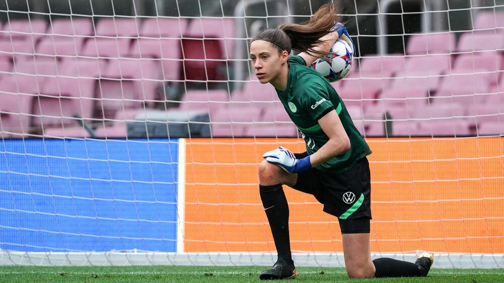 Die VfL Wolfsburg-Spielerin Julia Kassen rollt hockend den Ball aus dem Tor.