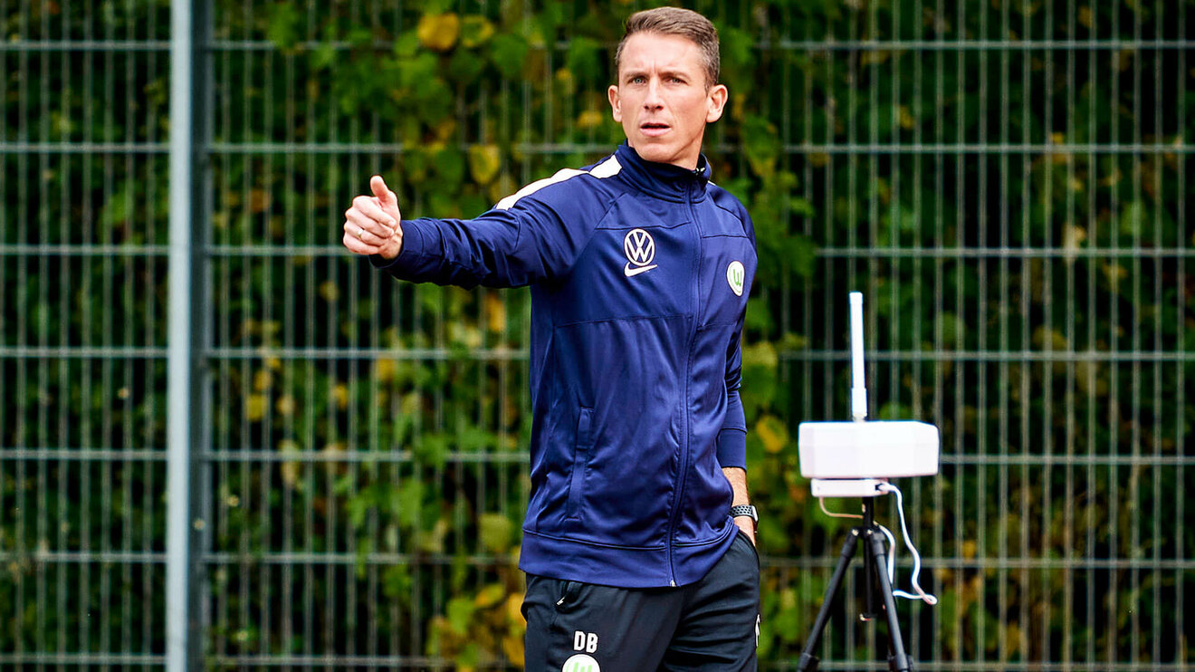 Der Trainer der VfL Wolfsburg U19 Mannschaft gibt Anweisungen vom Spielfeldrand aus.