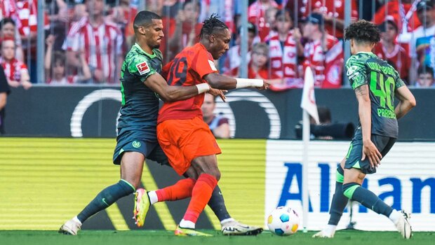 Die beiden VfL-Wolfsburg-Spieler Moritz Jenz und Kevin Paredes im Kampf um den Ball mit einem Gegenspieler.