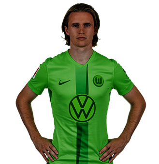 Der VfL Wolfsburg Spieler Patrick Wimmer posiert mit den Händen in der Hüfte.