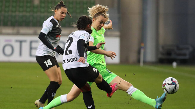 Eine Wölfin im Kampf um den Ball mit zwei Gegnerinnen im Spiel der VfL Wolfsburg Frauen gegen FC Sand.