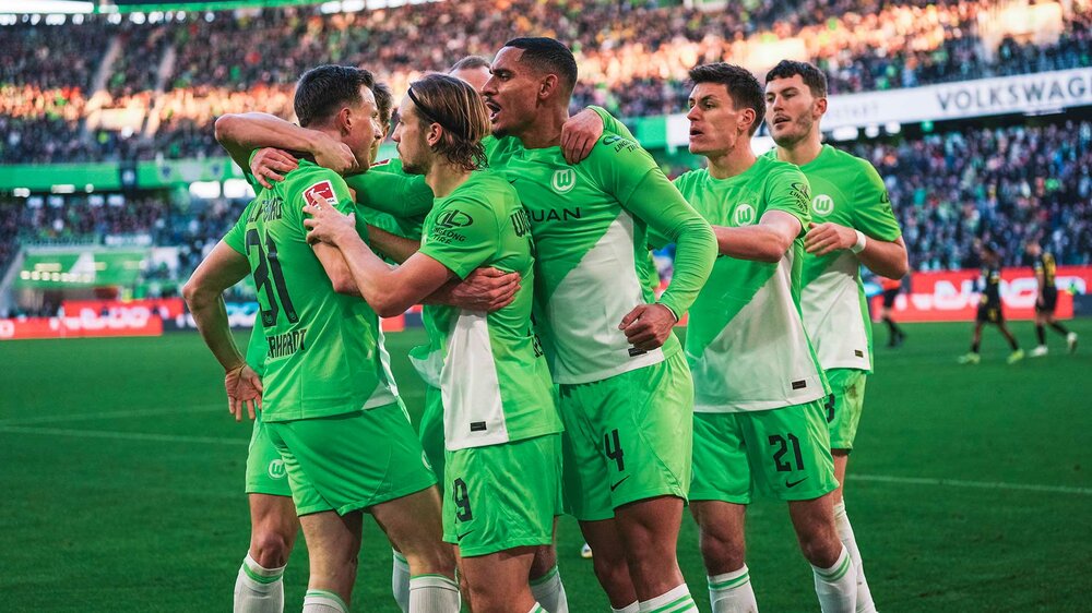 Die Spieler des VfL Wolfsburg bejubeln zusammen einen Treffer im Spiel.
