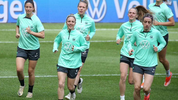Die Spielerinnen vom VfL Wolfsburg laufen sich warm.