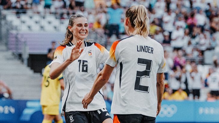 Die beiden VfL-Wolfsburg-Spielerinnen Jule Brand und Sarai Linder klatschen sich ab und jubeln im Trikot der deutschen Nationalmannschaft.