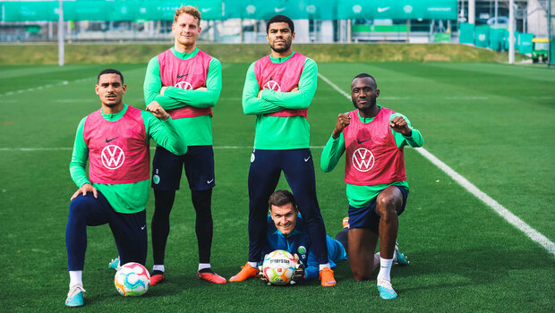 VfL Wolfsburg Spieler Cozza, Lacroix, Otavio, Guilavogui und Pervan posieren gemeinsam auf dem Trainingsplatz und halten den Daumen in die Höhe.