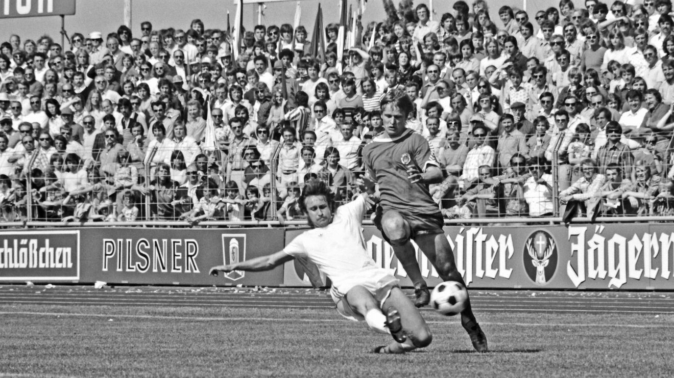 Ein historisches schwarz-weiß-Bild eines Zweikampfes bei einer Partie des VfL Wolfsburg gegen den FC St. Pauli.