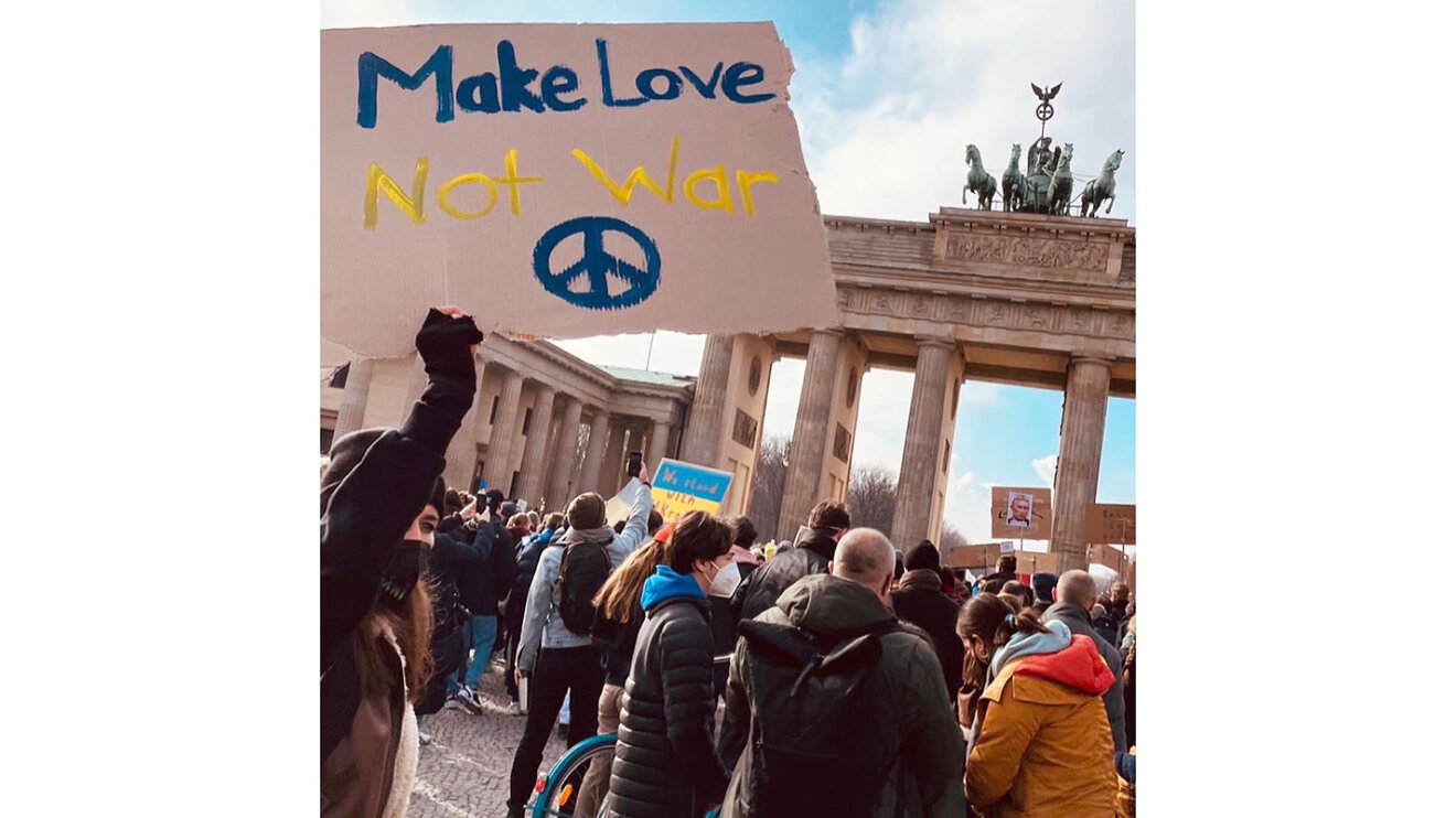 VfL Wolfsburg Spielerin Anna Blässe posiert mit "Make Love Not War" Plakat bei einer Friedensdemo in Berlin.