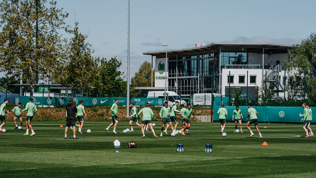 Die VfL-Wolfsburg-Spieler laufen mit dem Ball auf dem Trainingsplatz.
