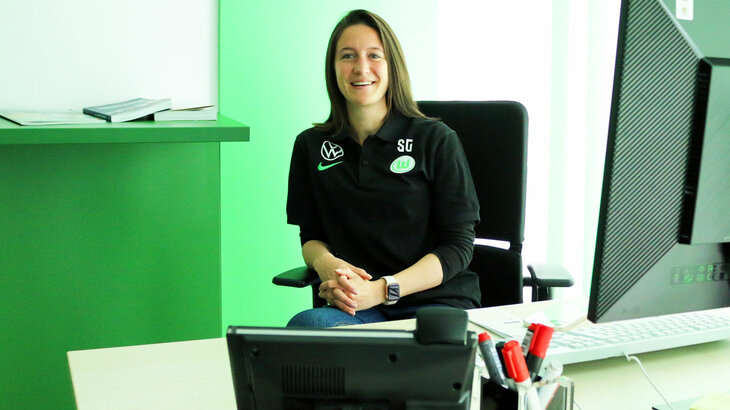 Die Vfl Wolfsburg Sportpsychologin Sina Gaebele sitzt auf einem Stuhl in der VfL-Fußball.Akademie.