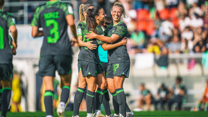 Die Spielerinnen des VfL Wolfsburg umarmen sich und bejubeln ihren Treffer. 