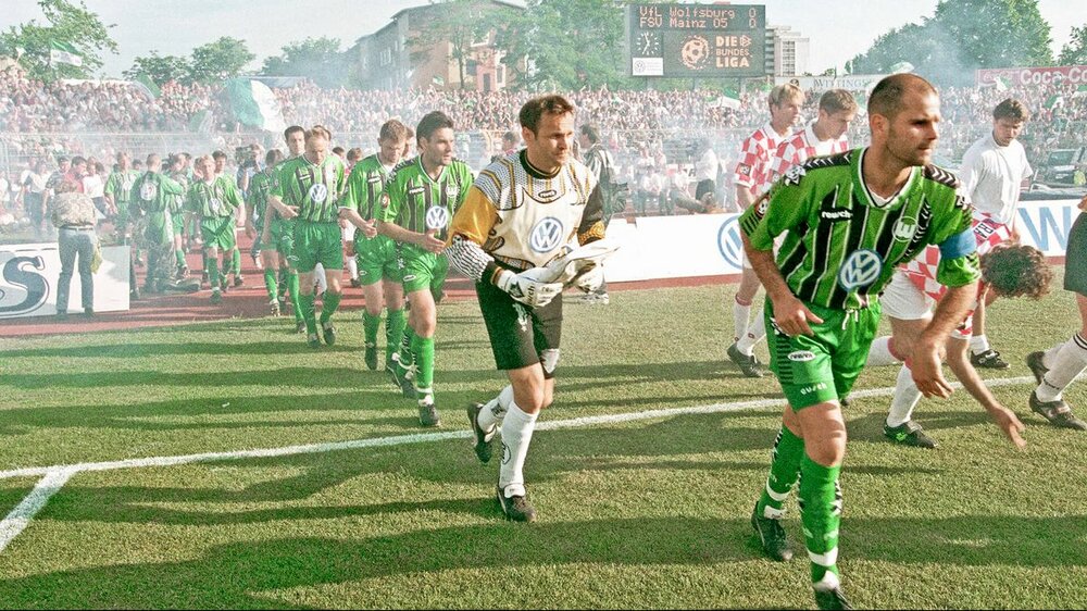 Spieler des VfL Wolfsburg laufen aufs Feld.