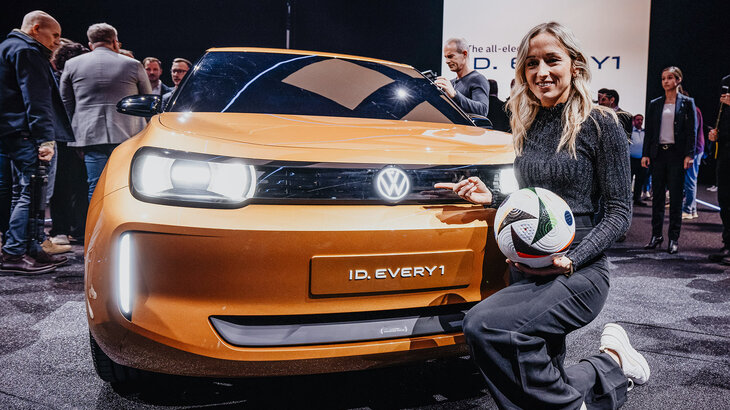 VfL-Wolfsburg-Spielerin Kathrin Hendrich nebendem neuen ID Modell von Volkswagen.