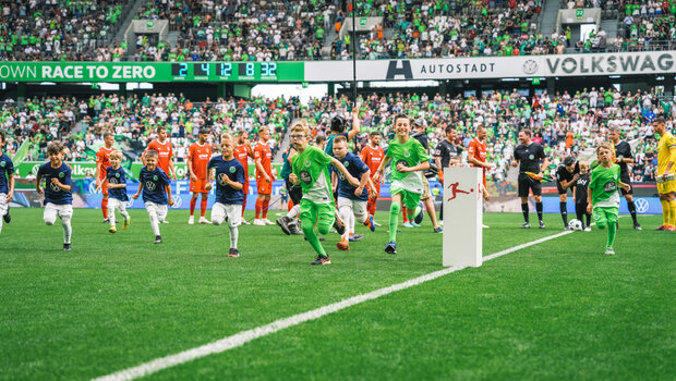 Einlaufkinder rennen beim Spiel des VfL Wolfsburg zurück zum Spielertunnel.