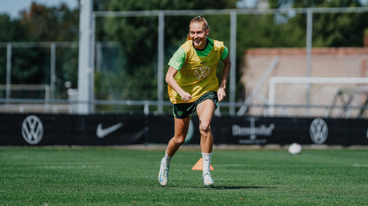 VfL-Wolfsburg-Spielerin Janina Minge läuft in Trainingsklamotten über den Platz.