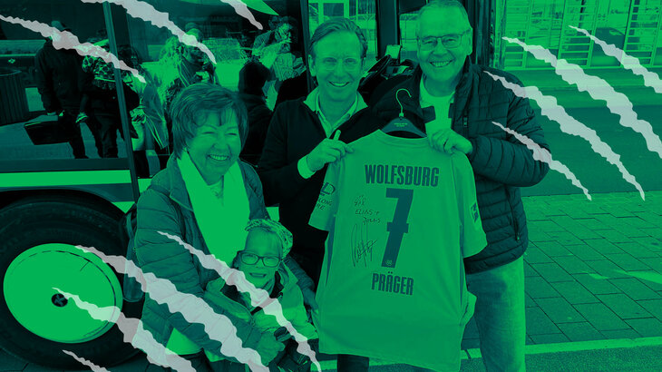 Roy Präger posiert mit Fans und hält ein signiertes Trikot in der Hand.