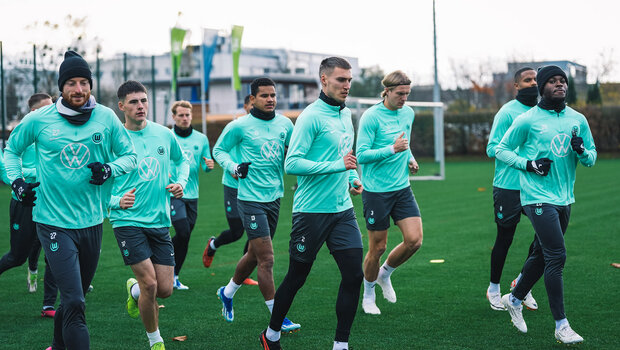 Das Team des VfL-Wolfsburg wärmt sich vor dem Training auf, in dem sie sich einlaufen.