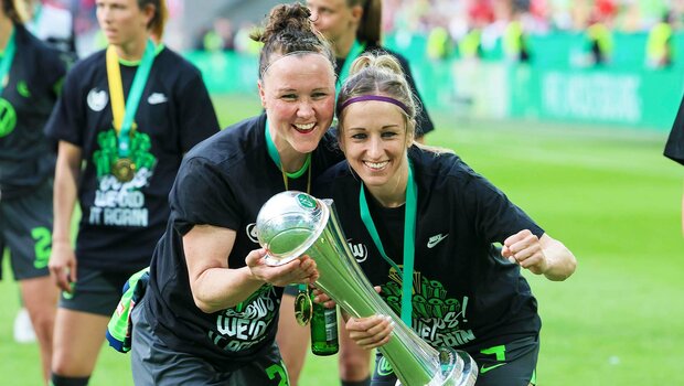 Die beiden Wolfsburg-Spierinnen Kathrin Hendrich und Marina Hegering posieren mit dem Pokal.