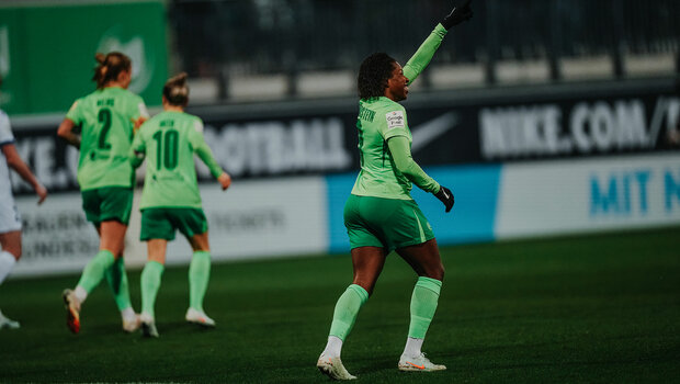 VfL-Wolfsburg-Spielerin Lineth Beerensteyn streckt den Arm in die Luft.