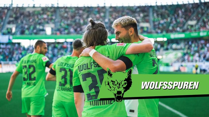 Patrick Wimmer und Jonas Wind vom VfL Wolfsburg umarmen sich mit einem Arm auf der Schulter des jeweils anderen.