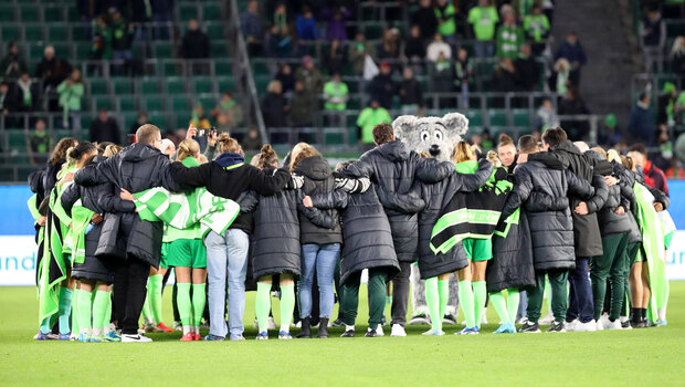 Die VfL-Spielerinnen von hinten, jubelnd in einer Reihe stehend zur Fan-Kurve.