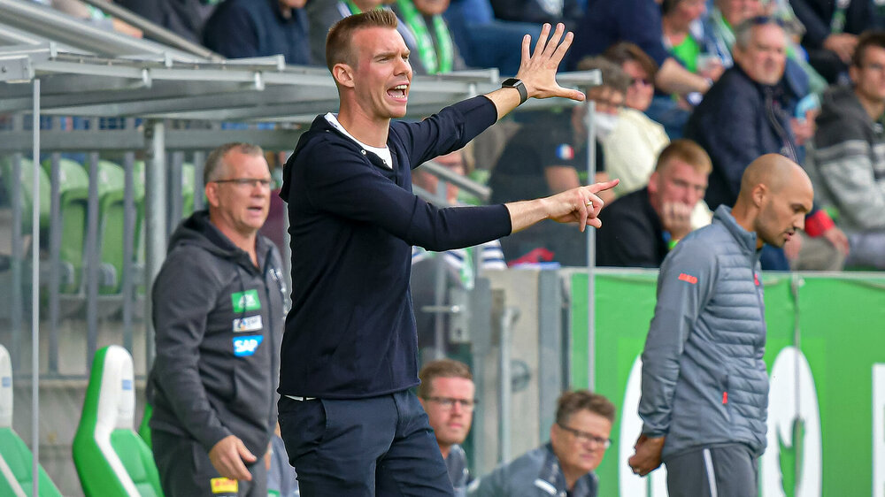 VfL Wolfsburg Frauen-Trainer Stroot steht am Spielfeldrand und gibt Anweisungen.