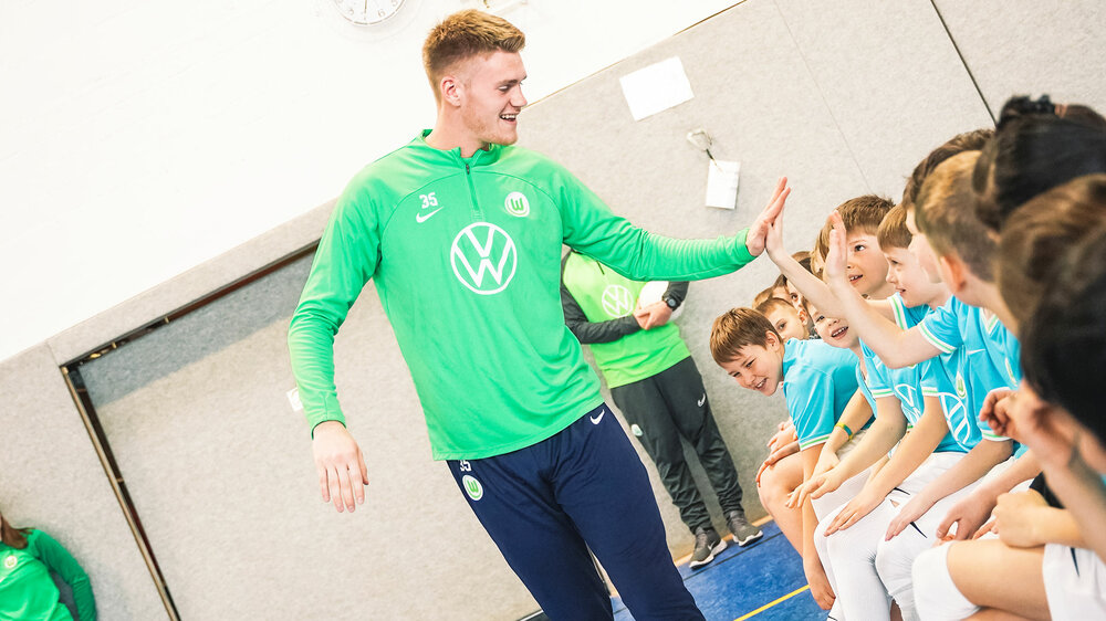 VfL Wolfsburg Keeper Philipp Schulze. klatscht sich mit Kindern ab. 