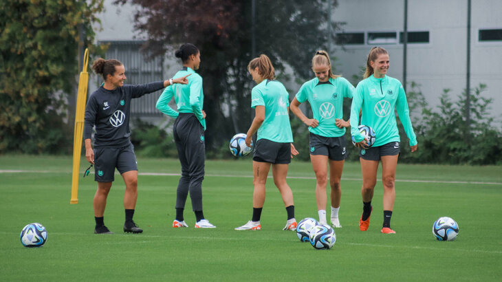 Die VfL Wolfsburg-Spielerinnen stehen auf dem Trainingsplatz.