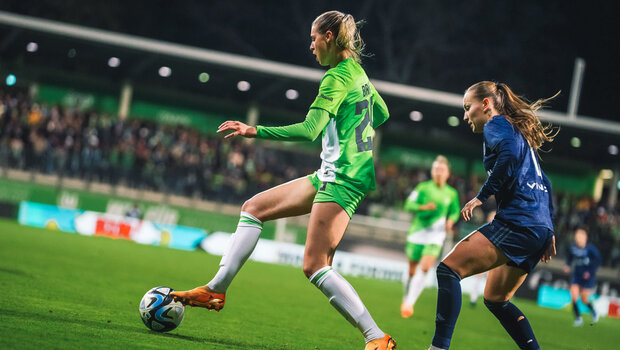 Die VfL Wolfsburg Spielerin Jule Brand hat eine Gegnerin im Rücken und verteidigt den Ball.