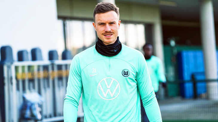 Yannick Gerhardt vom VfL Wolfsburg geht lächelnd auf den Trainingsplatz.