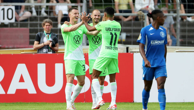 Tiago Tomas klatsch sich mit seinen Mitspielern vom VfL Wolfsburg ab.