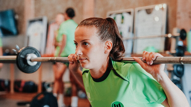 Die VfL-Wolfsburg-Spielerin Joelle Wedemeyer mit einer Langhantel auf den Schultern.