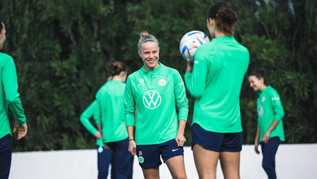 Die VfL-Wolfsburg-Spielerin Pia Wolter steht lachend auf dem Platz.