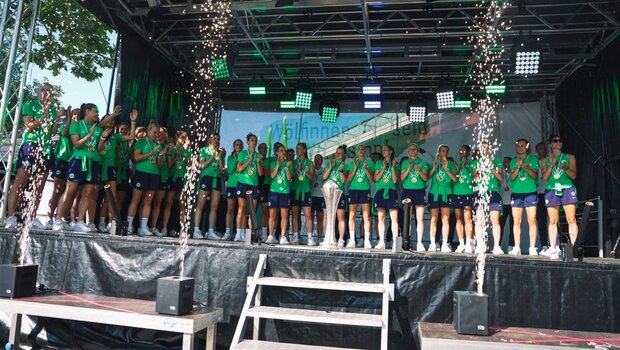 Die Frauenmannschaft des VfL Wolfsburg stehen mit dem Pokal auf der Bühne.