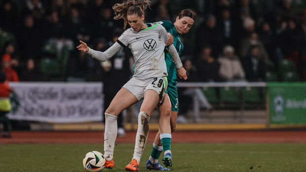 VfL-Wolfsburg-Spielerin Jule Brand verteidigt den Ball vor einer Gegenspielerin.