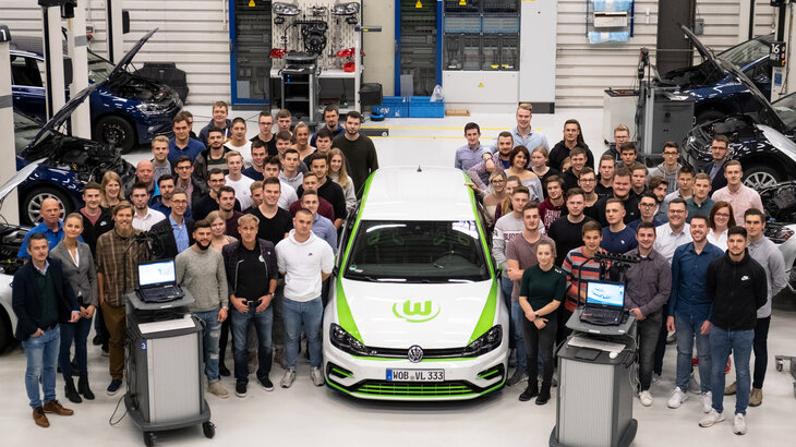 Gruppenbild der Auszubildenen mit Pierre Littbarski im VW Werk.