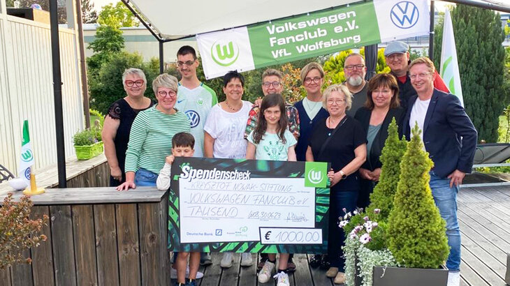 Der Volkswagen Fanclub des VfL Wolfsburg überreicht einen Spendencheck.