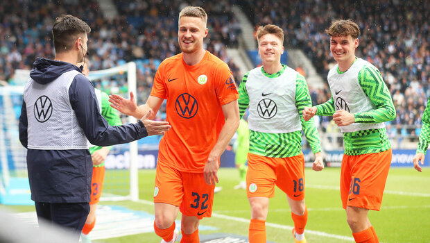 VfL-Wolfsburg-Spieler Svanberg bejubelt seinen Treffer mit einem Balljungen und Ersatzspielern.