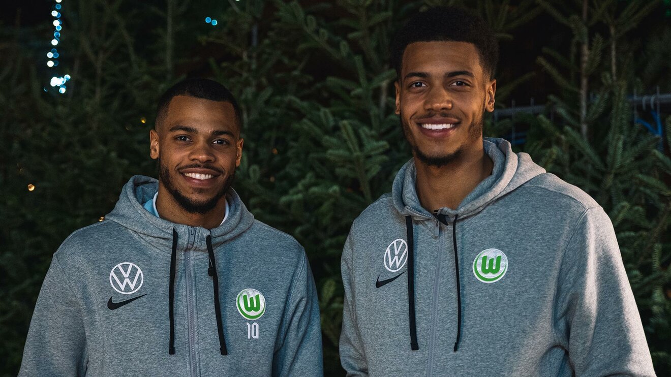 VfL-Wolfsburg-Spieler Lukas Nmecha und sein Bruder Felix lachen.