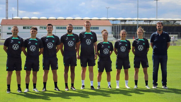 Das Trainerteam der VfL-Wolfsburg-Frauen steht nebeneinander auf dem Trainingsplatz.