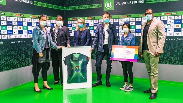 Ein gerahmtes Trikot des VfL Wolfsburg wird während der Aktion Schule fuer Vielfalt übergeben.