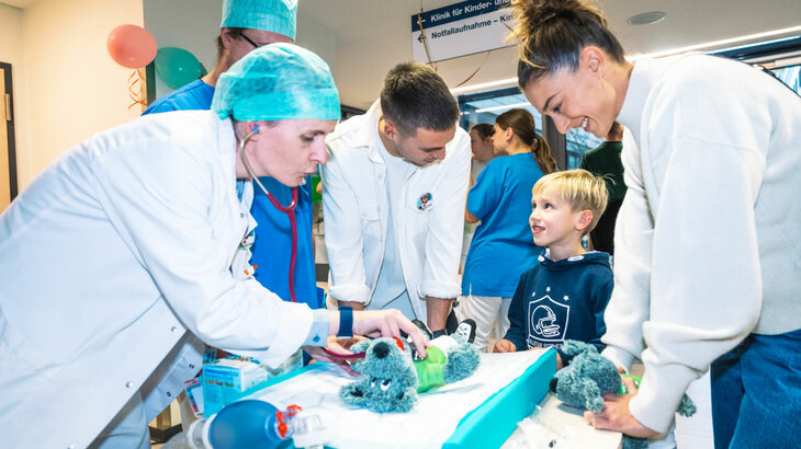 VfL-Wolfsburg-Spieler Kilian Fischer und Feli Rauch bringen ein Kind in der Kinderklinik zum Lächeln.