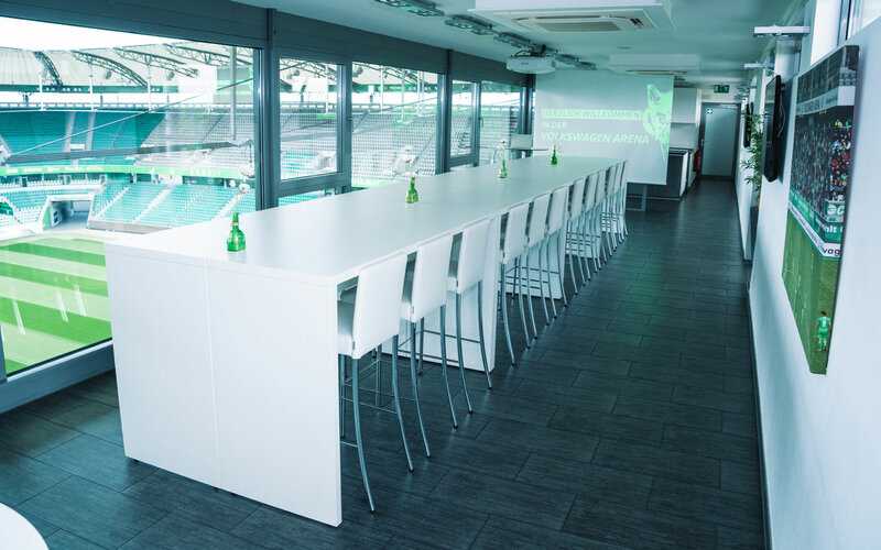 In einer Lounge der Volkswagen Arena vom VfL Wolfsburg steht ein langer weißer Tisch.