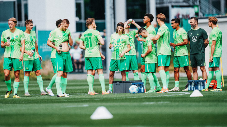 Die Spieler des VfL Wolfsburg trinken Wasser in einer Trainingspause.
