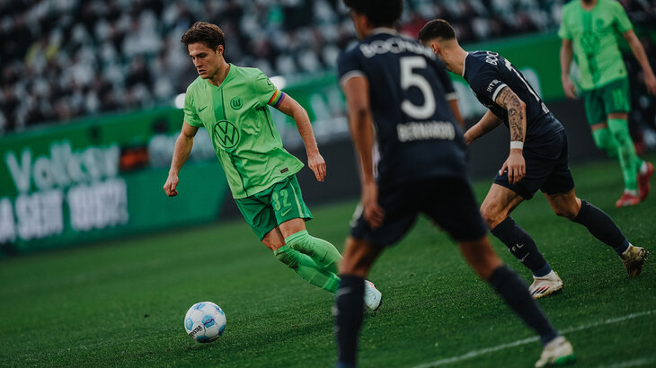 Ein VfL-Spieler ist mit dem linken Fuß am Ball. Von links und hinter ihm kommen wird er von zwei Gegenspielern gefolgt.