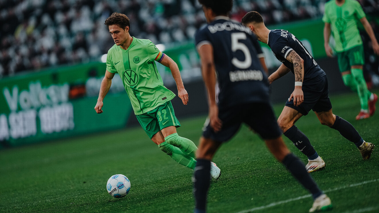 Ein VfL-Spieler ist mit dem linken Fuß am Ball. Von links und hinter ihm kommen wird er von zwei Gegenspielern gefolgt.