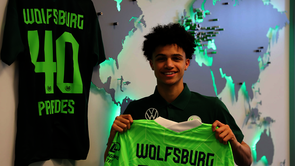 Der VfL-Wolfsburg-Spieler Kevin Paredes hält sein Trikot hoch.