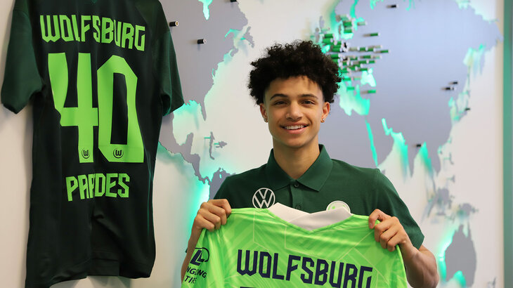 Der VfL-Wolfsburg-Spieler Kevin Paredes hält sein Trikot hoch.