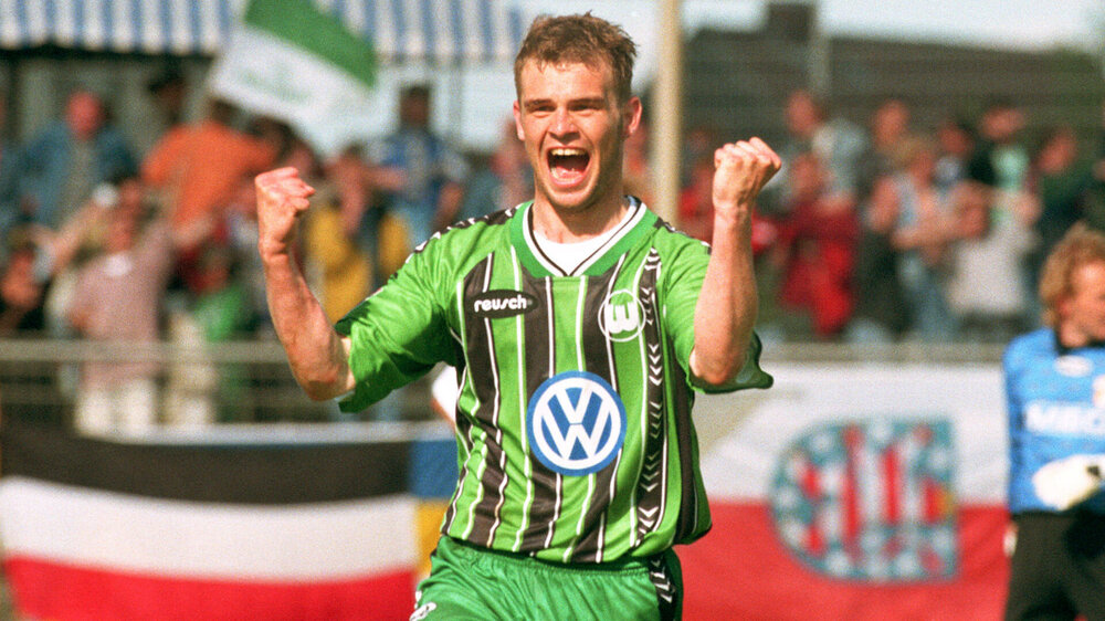 Der ehemalige VfL Wolfsburg Spieler ballt seine Fäuste und freut sich lautstark.