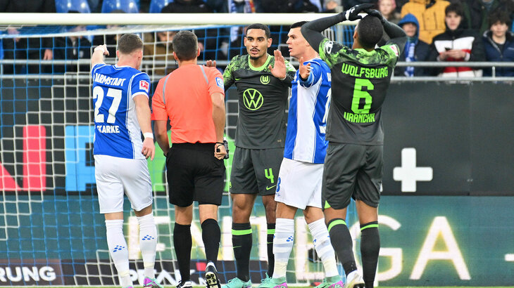 Der VfL-Wolfsburg-Spieler Maxence Lacroix diskutiert mit dem Schiedsrichter.