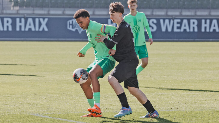 Ein Spieler der U17-Mannschaft des VfL Wolfsburg im Zweikampf mit einem Gegenspieler.